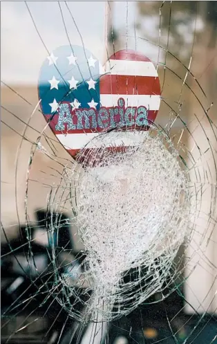  ?? ALYSSA SCHUKAR/THE NEW YORK TIMES ?? A sticker reading “America” is seen Aug. 25 in the window of a damaged business in Kenosha, Wisconsin.