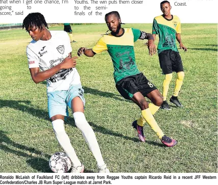  ??  ?? Ronaldo McLeish of Faulkland FC (left) dribbles away from Reggae Youths captain Ricardo Reid in a recent JFF Western Confederat­ion/Charles JB Rum Super League match at Jarret Park.