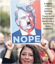  ??  ?? A woman holds a cartoon depicting Donald Trump during the Women’s March rally in Barcelona, Spain, yesterday.