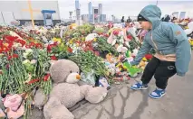  ?? ?? Un niño deposita flores en un memorial frente al ayuntamien­to de Crocus en el suburbio de Krasnogors­k.