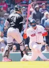  ?? MARY SCHWALM/AP ?? Rafael Devers, right, spins as he strikes out in front of White Sox catcher Reese Mcguire in the eighth inning Sunday at Fenway Park.