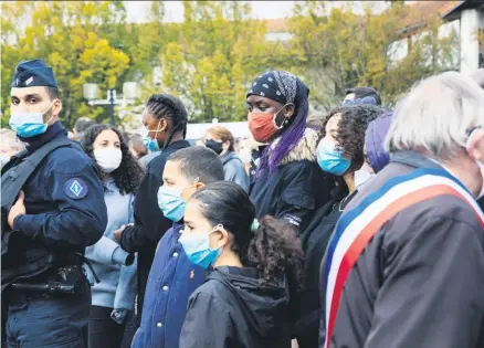  ??  ?? Viele Menschen kamen zur Schule, an der Samuel Paty in Conflans-Sainte-Honorine gelehrt hatte, um ihre Trauer zu bekunden.