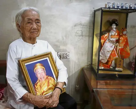  ?? — Reuters ?? Missing love: Xuan poses with a portrait of her husband Nguyen at her house in Hanoi, Vietnam.