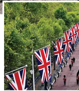  ?? ?? Magnificen­t in the sunshine: Union flags line The Mall as Her Majesty made her poignant journey yesterday to Westminste­r Hall