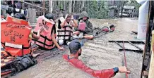  ?? ?? PHILIPPINE Coast Guard staff evacuate residents from their flooded homes on a makeshift raft in the town of Panitan, Capiz province, during Tropical Storm Megi yesterday. | AFP