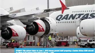  ?? —AFP ?? SYDNEY: This picture taken on June 1, 2018 shows ground staff preparing a Qantas Airbus A380 aircraft for flight at the Sydney Internatio­nal airport.