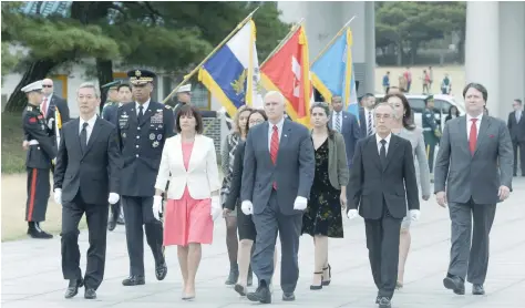  ??  ?? US Vice President Mike Pence, centre, and his wife Karen, centre left, inspect hour guard upon their arrival at the National Cemetery in Seoul on Sunday. — Reuters