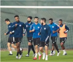  ??  ?? ↑ Sharjah players warm up during a training session.