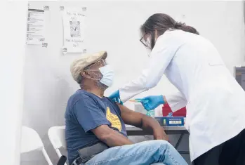  ?? DAVE SANDERS/THE NEW YORK TIMES ?? A man receives a COVID-19 booster shot on Sept. 27 in the Bronx borough of New York.