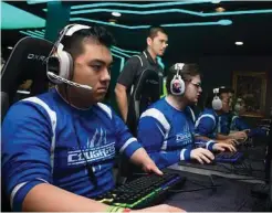  ?? Kaci Smart/ Columbia College Public Relations via New York Times ?? Columbia College eSports players Ian Alexander, from left, R.J. Bohnak and Jonathan Song play the game League of Legends in the college’s Game Hut as coach Duong Pham guides them.