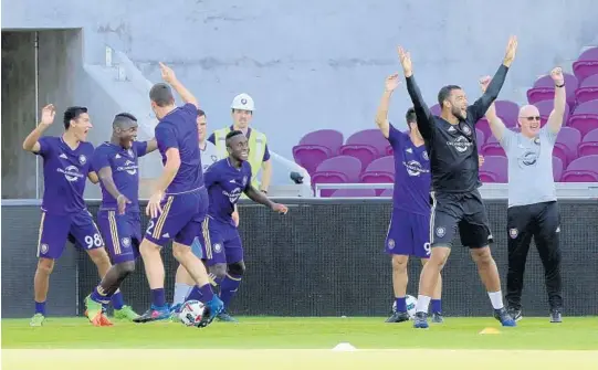  ?? CASSIE ARMSTRONG/STAFF PHOTOGRAPH­ER ?? Orlando City players celebrate after besting their teammates during a training session at the Lions’ new stadium Tuesday. The team’s season opener at the new venue is Sunday.