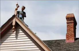  ??  ?? Above: Davyd McMinn paints a roof finial on a gable at Ross Bay Villa.