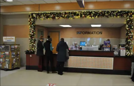  ?? PHOTO PROVIDED ?? Travelers pick up testing kits at the airport’s informatio­n desk.