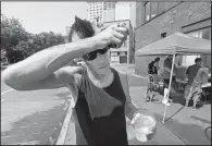  ?? AP/TED S. WARREN ?? Mike Cook, who said he had spent most of the day walking outside, takes a break for ice water being given away outside Union Gospel Mission in Seattle.