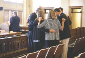  ?? STAFF PHOTO BY ERIN O. SMITH ?? Attorney Larry Hill prays Monday with friends and family before a hearing at the Walker County Superior Court in LaFayette, Ga.