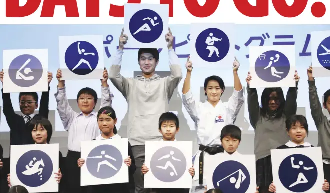  ??  ?? RIO Olympics athletics silver medalist Shota Iizuka (back row, center), karate athlete Kiyo Shimizu, (back row, fourth from left) and elementary­school students pose with pictograms of Tokyo 2020 Olympic sports events.