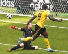  ?? Catherine Ivill / Getty Images ?? Belgium’s Romelu Lukaku scores his second goal of the match past Tunisia’s Farouk Ben Mustapha to tie Cristiano Ronaldo for the 2018 World Cup lead with four goals.