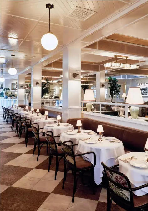  ??  ?? Above — The dining room features darker-coloured furnishing­s and tumbled marble tiles that contrast with high-gloss white timbers.