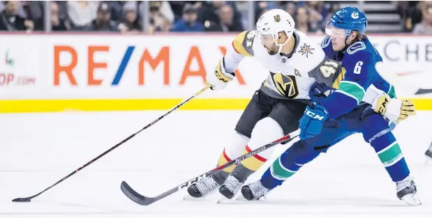  ?? — THE CANADIAN PRESS ?? Pierre-Edouard Bellemare of the Vegas Golden Knights tries to fend off Canucks winger Brock Boeser while skating with the puck during the first period on Thursday night at Rogers Arena.