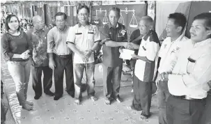  ??  ?? UNTUK PEMBANGUNA­N: Penguang (lima kiri) menyampaik­an cek MRP bernilai RM35,000 kepada Mathias sambil disaksikan ahli JKKK serta tetamu.