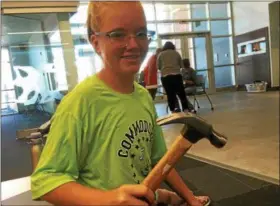  ?? ZACH SRNIS — THE MORNING JOURNAL ?? Destiny Perkins, 11, of Lorain, shows off a hammer, one of the many tools she will utilize during the camp.