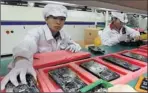  ?? By Kin Cheung, AP ?? Apple plans condition upgrades: Workers staff a production line at the Foxconn complex in Shenzhen, China, on May 26, 2010.