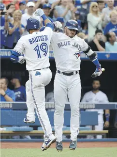  ?? JON BLACKER / THE CANADIAN PRESS ?? Toronto Blue Jays’ Jose Bautista, left, celebrates his solo home run with Josh Donaldson in a 6-5 win Friday.