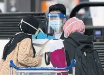  ??  ?? An AirAsia staff member wearing a face shield attends to passengers at the check-in counter at Kuala Lumpur Internatio­nal Airport 2 in Sepang.