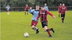  ??  ?? Liam Griffiths takes on Liam Griffiths! Two namesakes clash for the ball in the game between Bro Goronwy (red and black) and Cefni FC.