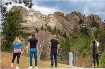  ??  ?? Tourists take photos of Mount Rushmore National Memorial.