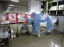  ?? Marco Ugarte Associated Press ?? A MEDICAL TEAM puts a COVID- 19 patient in an isolation chamber at a Mexico City hospital. Mexico has the world’s highest rate of deaths from the disease.