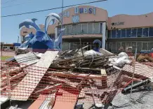  ??  ?? A pile of rubble still occupies an area in front of a souvenir store called Bay Quest on Cotter Avenue.