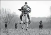  ?? AP/VADIM GHIRDA ?? A villager takes a warm-up ride on his horse before an Epiphany celebratio­n race Sunday in Pietrosani, Romania. According to local tradition, a religious service is held, then villagers have their horses blessed with holy water and compete in a race.