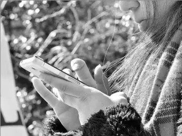  ??  ?? A young girl uses her smartphone in Tokyo on Feb 10. High school girls in Japan spend an average of seven hours a day on their mobile phones, a new survey has found, with nearly 10 per cent of them putting in at least 15 hours. — AFP photos