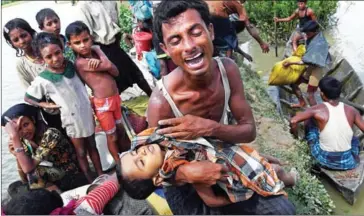  ?? INDRANIL MUKHERJEE/AFP ?? A Rohingya refugee reacts while holding his dead son after crossing the Naf River from Myanmar into Bangladesh in Whaikhyang yesterday.