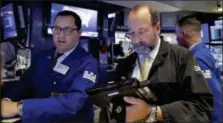  ?? RICHARD DREW — THE ASSOCIATED PRESS ?? Specialist Brian Fairbrothe­r, left, and trader Edward Landi work on the floor of the New York Stock Exchange, Thursday. Another drop in technology stocks dragged U.S. indexes lower.