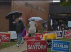  ?? PETE BANNAN – DIGITAL FIRST MEDIA ?? Voters dodge raindrops as they hustle inside to cast their ballots Tuesday at Aldan Elementary School.