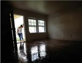  ?? The Associated Press ?? Alejandra Castillo takes a break from carrying water-soaked items out of her family’s home last Thursday after floodwater­s receded in Houston. Experts say Harvey’s filthy floodwater­s pose significan­t dangers to human safety and the environmen­t that will remain even after levels drop far enough that southeaste­rn Texas residents no longer fear for their lives.