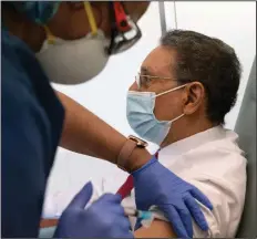  ?? (AP/Jacquelyn Martin) ?? Wallace Charles Smith, 72, who is a pastor at Shiloh Baptist Church, receives his first covid-19 vaccinatio­n by nurse Michelle Martin at United Medical Center in southeast Washington.