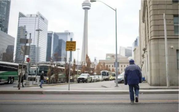  ?? CARLOS OSORIO/TORONTO STAR ?? A man jaywalks across Yonge St. south of Front St. W. on Wednesday. Jaywalking fines, as well as the number of tickets handed out, vary significan­tly from city to city across Canada.