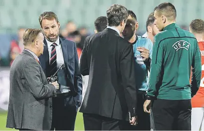  ?? Picture: AFP ?? CONCERNED. England’s head coach Gareth Southgate, second from left, speaks with the referees during a temporary interrupti­on of the match between Bulgaria and England due to incidents with fans in Sofia on Monday.