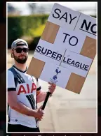  ??  ?? Spurred on: a Tottenham fan makes clear his feelings about the breakaway plans outside the club’s training base