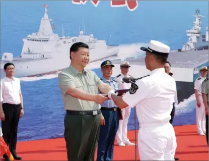  ?? LI GANG / XINHUA ?? President Xi Jinping presents the name certificat­e for the Changzheng 18, a nuclear-powered ballistic missile submarine, to its captain at a naval base in Sanya, Hainan province, on April 24.