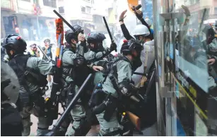  ?? (Susana Vera/Reuters) ?? RIOT POLICE charge at anti-government protesters at Wan Chai district on China’s National Day yesterday in Hong Kong.