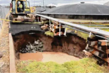  ?? CAA/Contribute­d photo ?? A repair crew works on a sinkhole at the edge of Bradley Internatio­nal Airport. The sinkhole formed due to a failed storm pipe away from runways.