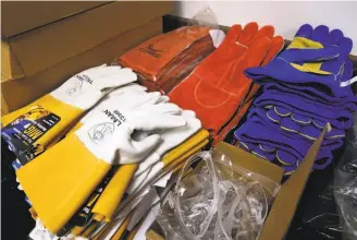  ?? Paul Chinn / The Chronicle ?? New welding gloves are stacked in a closet in the refurbishe­d welding and metal shop classroom at Kennedy High School in Richmond.