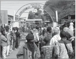  ?? AP/YACOUBA CISSE ?? People gather outside a hospital where the injured were taken after a suicide attack Wednesday at a military base in Gao, Mali.