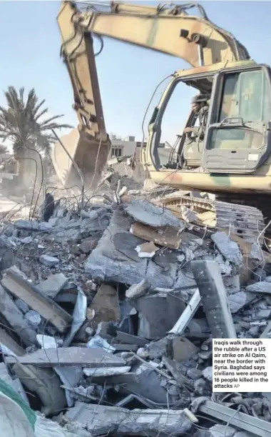  ?? ?? Iraqis walk through the rubble after a US air strike on Al Qaim, near the border with Syria. Baghdad says civilians were among 16 people killed in the attacks AP