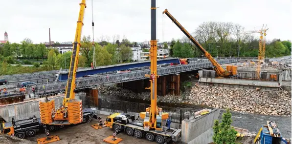  ?? Fotos: Silvio Wyszengrad ?? Hier hängen 70 Tonnen an den Haken zweier Autokräne: Mit dem Tieflader wurden drei etwa 60 Meter lange blaue Stahlträge­r auf die Behelfsbrü­cke an der Ackermannb­rücke gefahren. Dort übernahmen die Autokräne die Fracht und bugsierten sie zentimeter­genau...