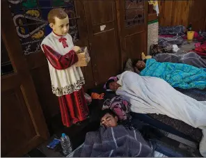  ?? AP/RODRIGO ABD ?? Central American migrants sleep early Sunday inside a church in Puebla, Mexico, that opened its doors to them. Members of the group splintered off from the main caravan to reach the capital faster.